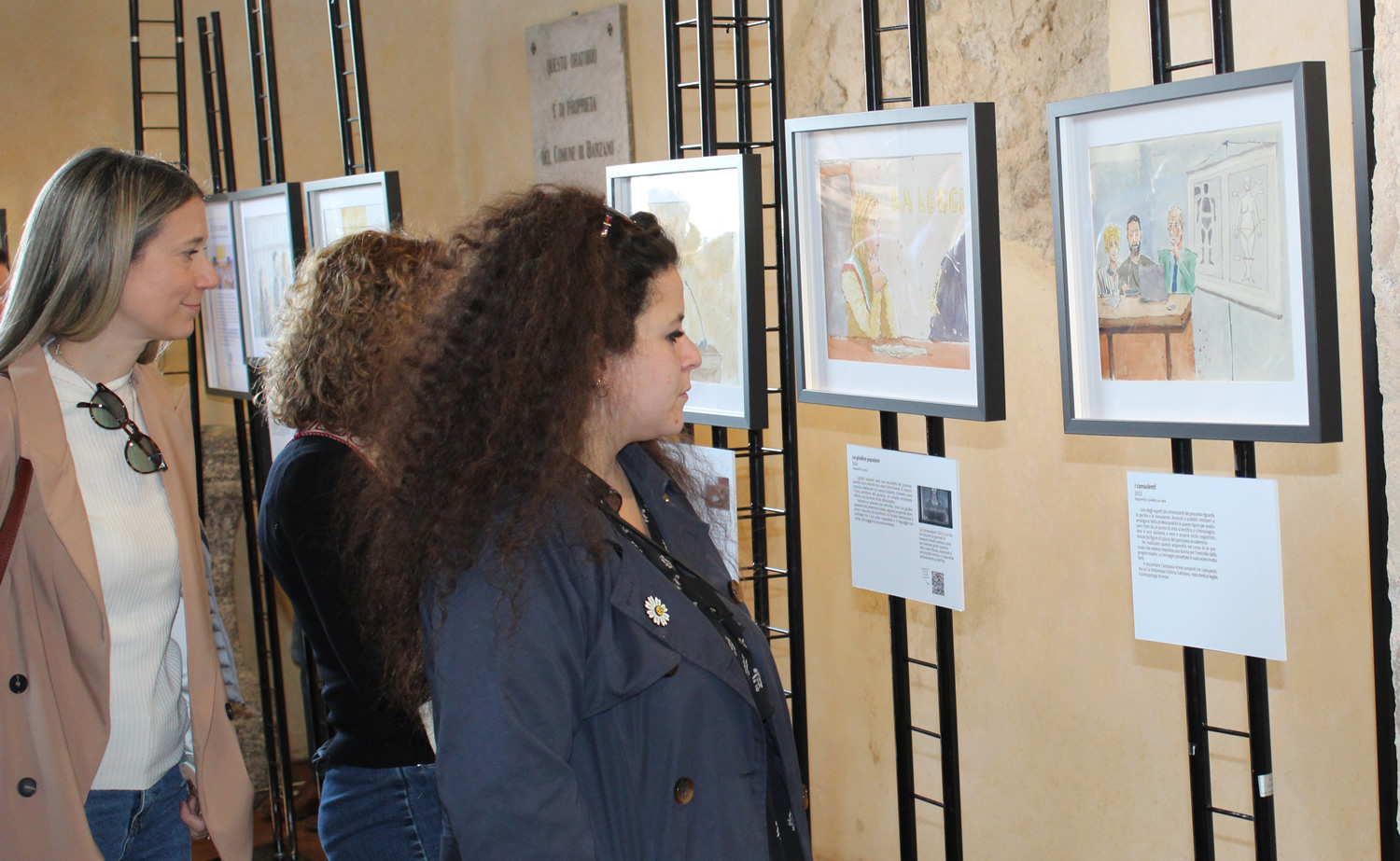 Visitatori osservano le illustrazioni a Barzanò